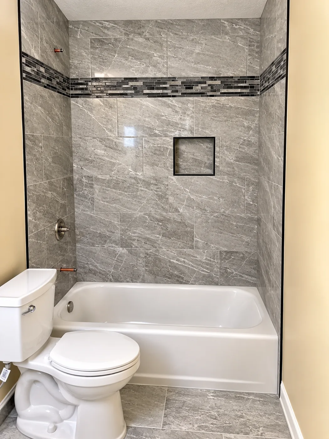 Gray Tile Tub Surround: Tile surround with mosaic accent band and recessed niche