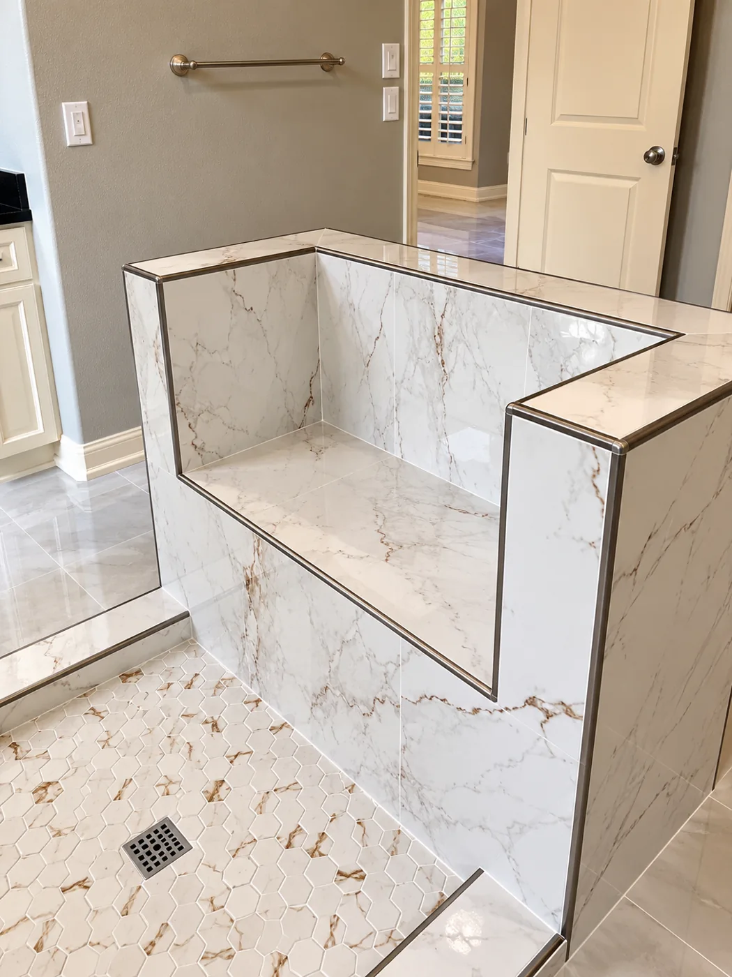 Custom Shower Bench: Marble-look bench with a hexagonal mosaic shower floor