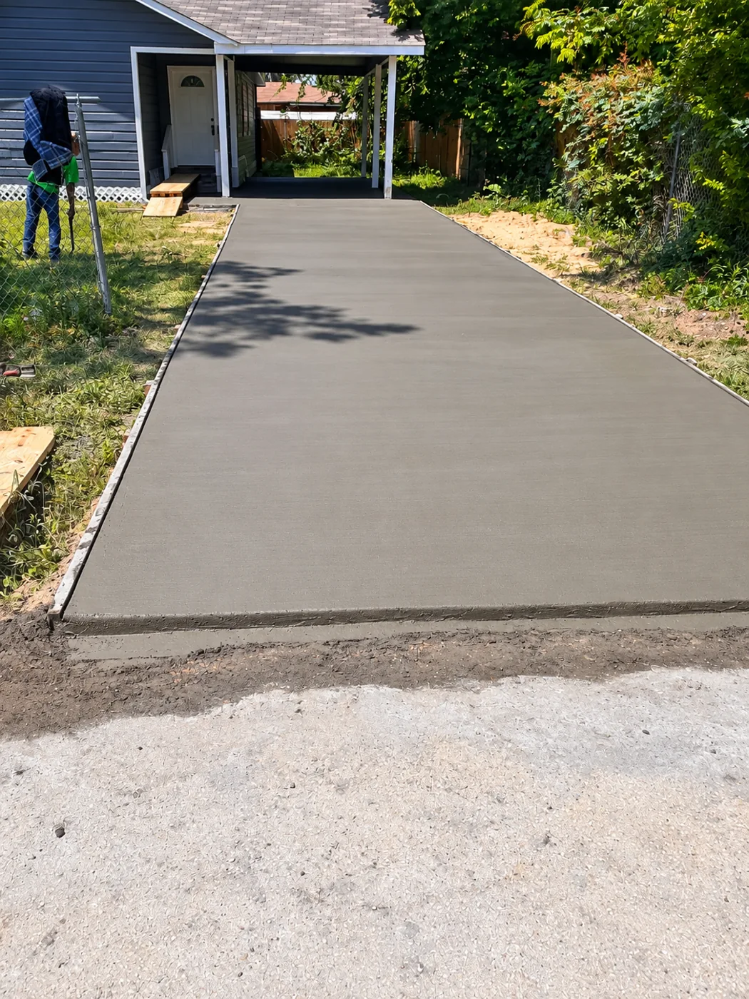 Concrete Driveway: Concrete surface leading to the covered entrance