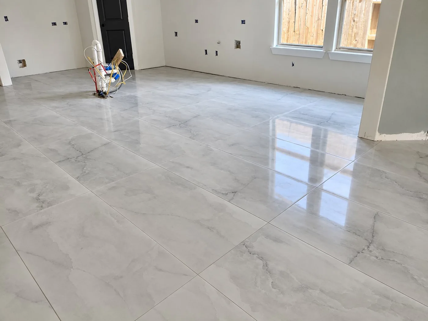 Large-format polished porcelain tile installed across an open interior